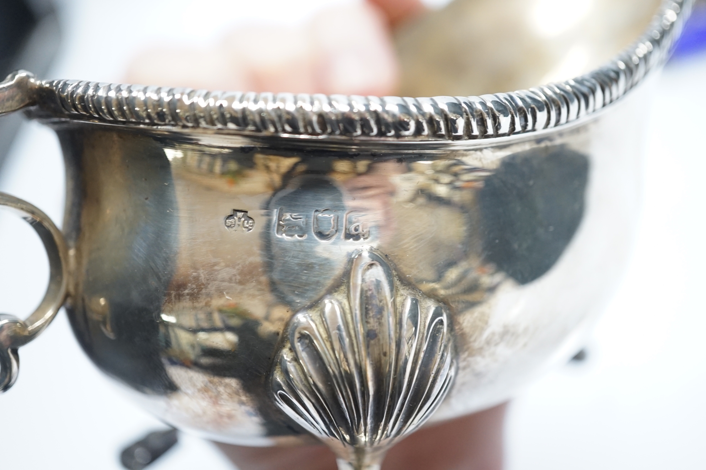 A late Victorian silver sauceboat, with flying scroll handle, William Hutton & Sons, London, 1898 and a George III pierced silver oval salt, with blue glass liner, London, 1768, 12.2oz.